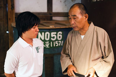 日本の老舗酒蔵で働く青年・ナオト（濱田岳）と社長（でんでん）、映画『サケボム』より