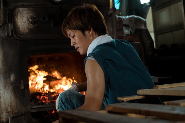 銭湯の聖域・釜場にて薪をくべる拓海（松坂桃李）、映画『湯を沸かすほどの熱い愛』（中野量太監督）より