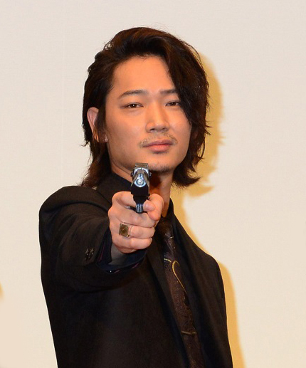 拳銃を構えてポーズをとる綾野剛、映画『日本で一番悪い奴ら』初日舞台あいさつにて